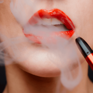 woman with red lipstick using a red vape