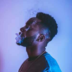 a man in a purple room vaping