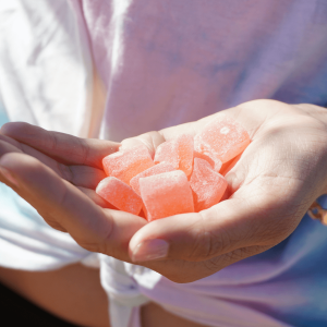 a person holding pink gummy edibles