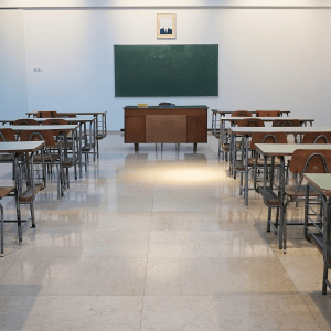 an empty classroom with desks and a chalkboard