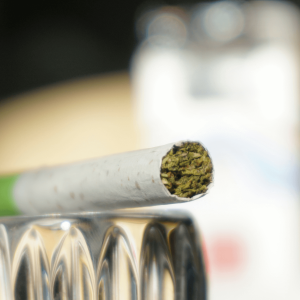 a white and green cigarette filled with hemp flower