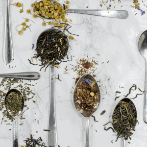 flat lay of spoons containing various dried tea leaves