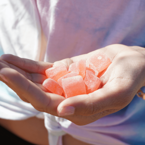 a woman holding pink gummies