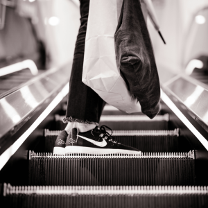 a person carrying shopping bags on an escalator