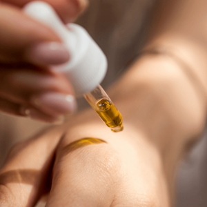 a person applying gold cannabis oil