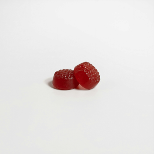 2 red gummies sitting against a white surface