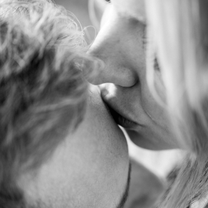 grayscale image of a woman kissing a man’s forehead