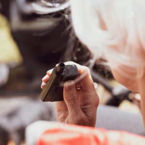 a person holding a black square vape