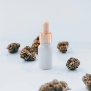 a bottle surrounded by cannabis nugs