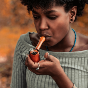 a girl smoking from an orange pipe