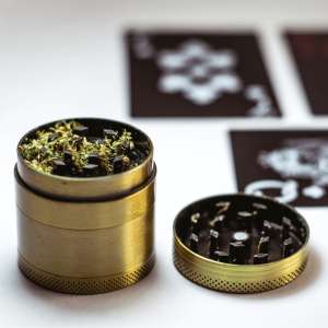 a gold grinder with green leaves inside