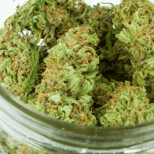 glass jar filled with green cannabis buds