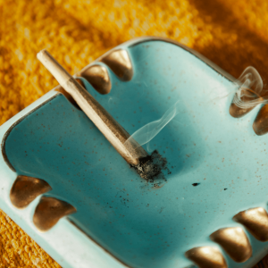 a joint burning on a blue ashtray