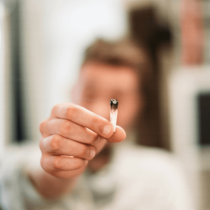 a person holding up a burnt joint