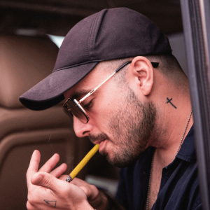 man with neck tattoo smoking blunt