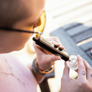 a person using a dip device to smoke hash