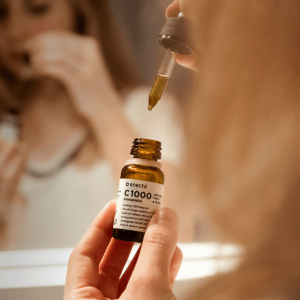 selective focus photography of a girl holding C1000 bottle