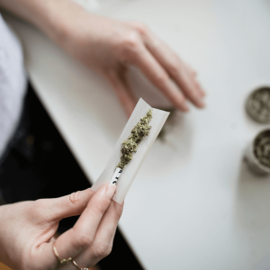 person in white shirt rolling a joint