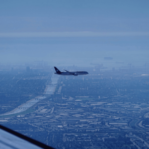 a plane against a blue sky flying into lax