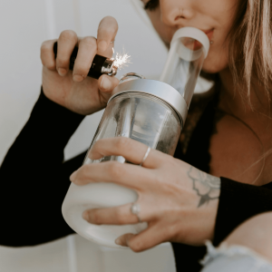 a woman using a lighter to spark a bong