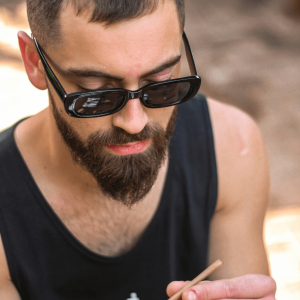 man with a beard rolling a joint