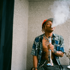 a man smoking from a glass bong