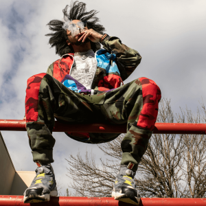 a man sitting on a red railing and smoking a joint