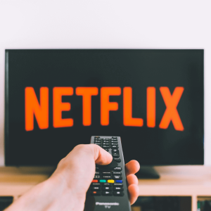 person pointing remote at netflix screen