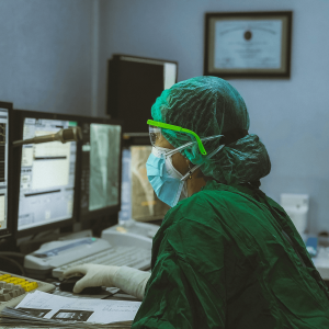 person in scrubs at a computer in a hospital