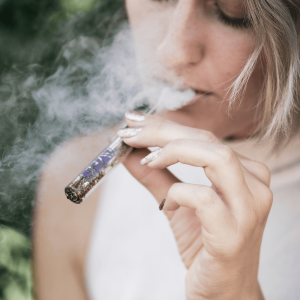 girl smoking cannabis flower from a one-hitter