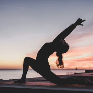 girl doing a yoga pose at sunset