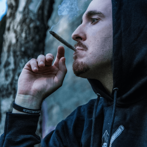 man in black hoodie smoking a joint