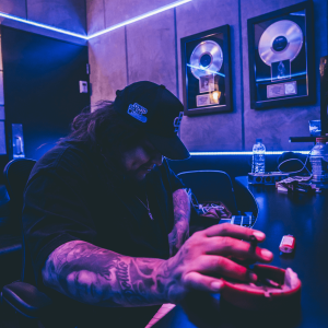 man with joint and ashtray in a purple studio