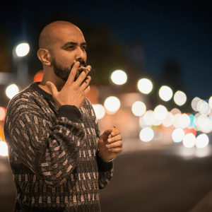 man in a sweater smoking a joint