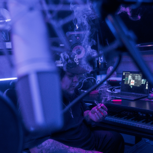 man in purple studio smoking a joint