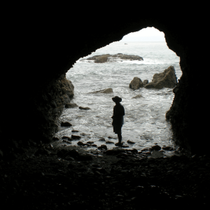 person in a cave by the beach