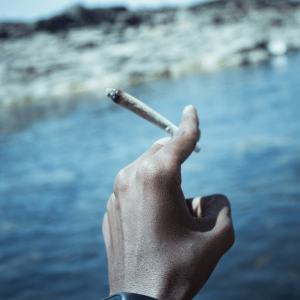 man’s hand holding a joint