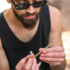 man with beard rolling a joint