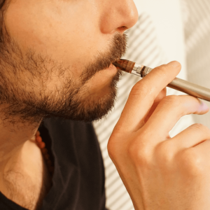 man smoking from a cannabis vape pen