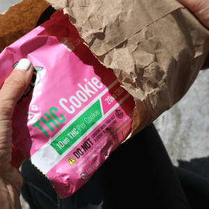 person pulling THC cookie out of brown package