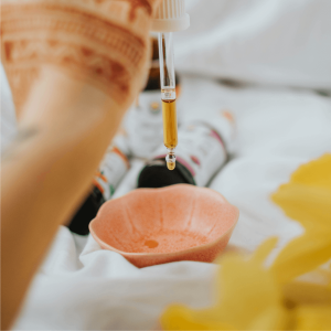 hand dropping tincture in pink dish