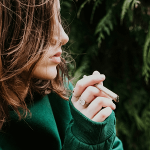 girl in green sweater smoking a joint