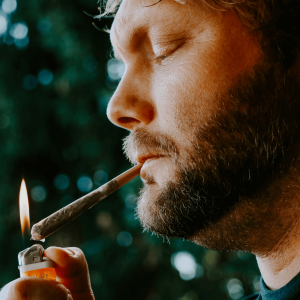 man with beard smoking a joint