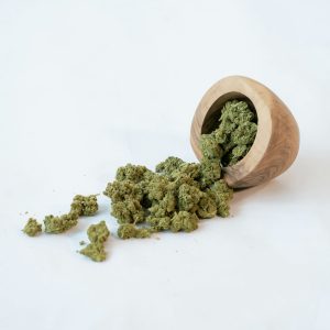 cannabis flower spilling out of wooden pot