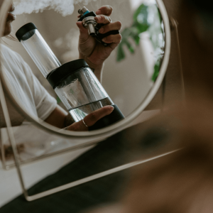 person smoking bong in mirror