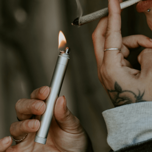 person lighting joint with silver lighter
