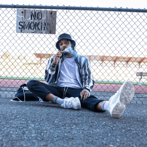 man sitting and smoking next to sign