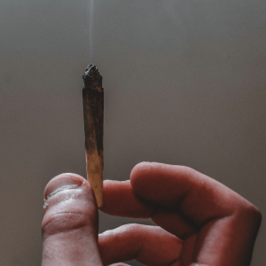 person holding up burning joint