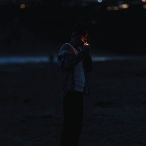 man lighting joint on beach